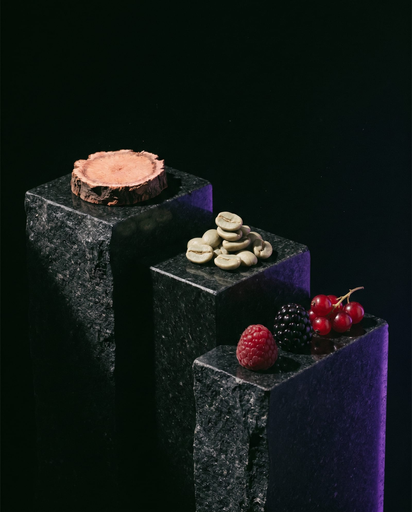 Rhodiola root, green coffee beans and berries on dark stone plinths